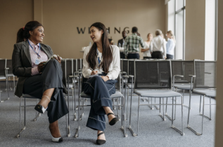 2 Women Sitting in Office Chairs
